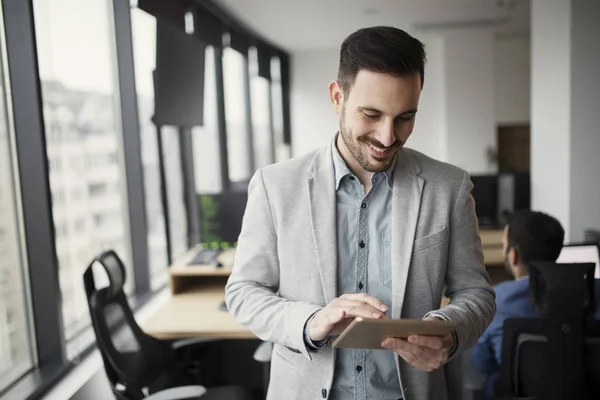 Bild av stilig man använder surfplatta i office — Stockfoto