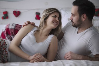 Güzel kadın ve çekici adam yatakta yatarken