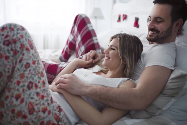 Schöne Frau und attraktiver Mann auf dem Bett liegend — Stockfoto