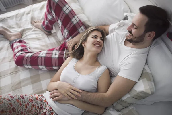 Mulher bonita e homem atraente deitado na cama — Fotografia de Stock