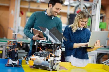 Robot bilimi genç öğrencileri robotu test için hazırlıyorlar.