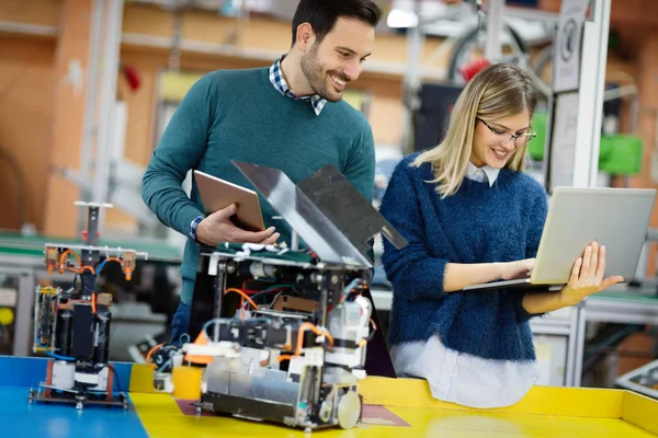 Robot bilimi genç öğrencileri robotu test için hazırlıyorlar.