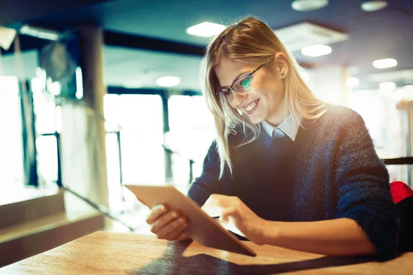 Happy young woman using tablet at coffee shop — Stock Photo, Image