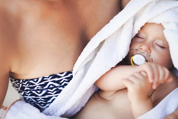 Junge Mutter hält ihr schlafendes Neugeborenes — Stockfoto