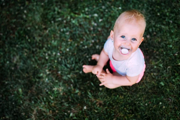 Retrato de bebê adorável sentado no gramado — Fotografia de Stock