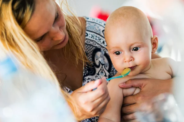 Retrato de la madre alimentando a su bebé con cuchara — Foto de Stock