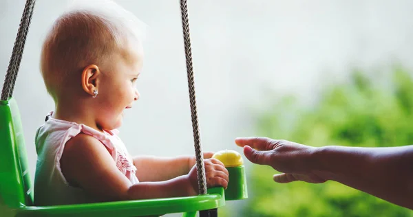 Beautiful Baby swinging outdoor with caring faimly — Stock Photo, Image