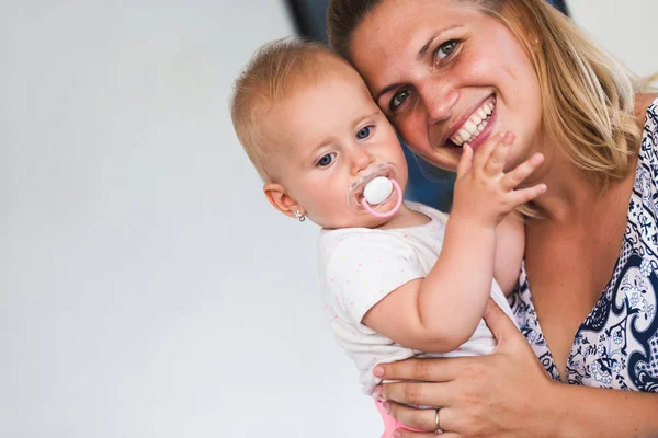 Retrato de madre sonriente sosteniendo a su bebé — Foto de Stock