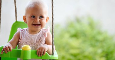 Mutlu neşeli bebek salıncak iken üzerinde gülümseyen