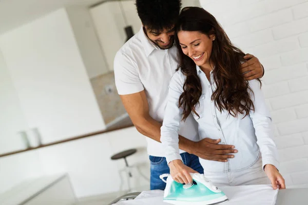 Pareja joven en casa haciendo tareas domésticas y planchado — Foto de Stock