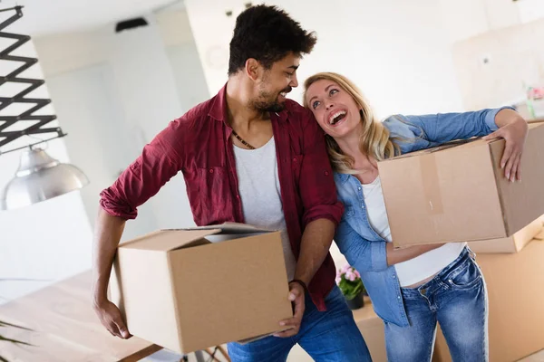 Casa, la gente, el movimiento y el concepto de bienes raíces - feliz pareja divirtiéndose mientras se muda en — Foto de Stock