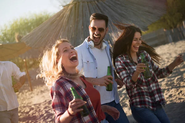 笑いとビールを飲む若い友人のグループ — ストック写真