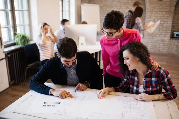 Gruppe av unge perspektivdesignere som drøfter sine verv – stockfoto