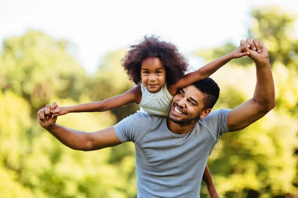 Retrato do jovem pai carregando sua filha de costas — Fotografia de Stock