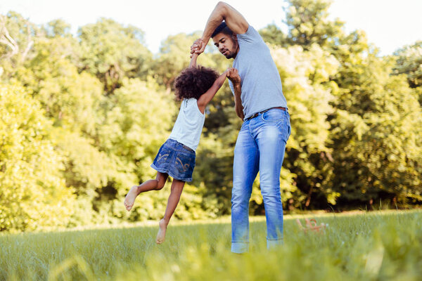 Портрет молодого отца, играющего со своей дочерью
