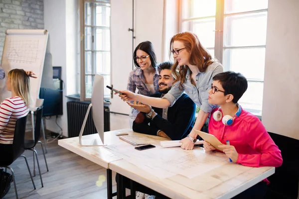 Gruppe av unge perspektivdesignere som drøfter sine verv – stockfoto