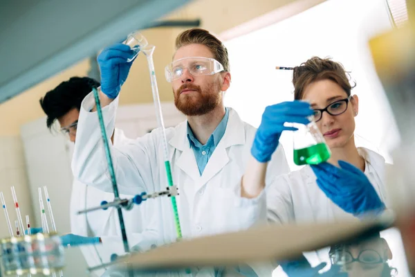 Jóvenes estudiantes de química trabajando en laboratorio — Foto de Stock