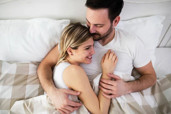 Mulher bonita e homem atraente deitado na cama — Fotografia de Stock