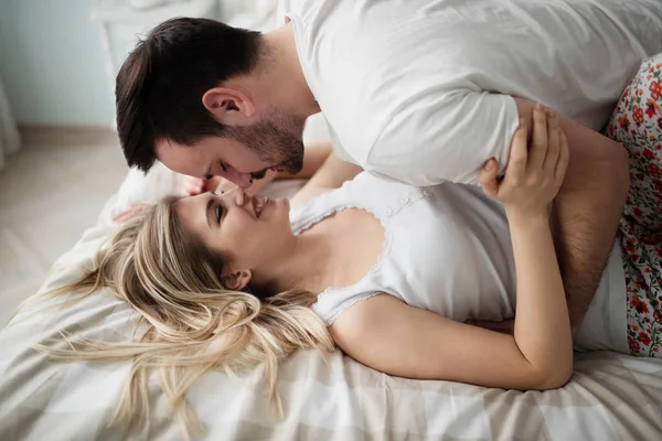 Beautiful couple being romantic and passionate in bed — Stock Photo, Image