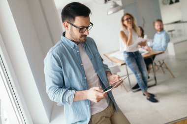Ofiste meslektaşları ile çalışan yakışıklı tasarımcı mimar