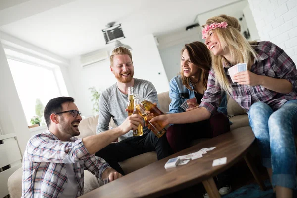 Amigos se divertindo e sorrindo juntos dentro de casa — Fotografia de Stock