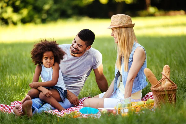 Förolämpad liten flicka sitter med föräldrar på picknick — Stockfoto