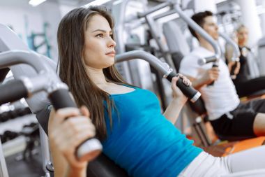 Spor salonunda egzersiz yapan insanlar