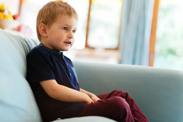 Felice ragazzo seduto sul divano del soggiorno — Foto Stock