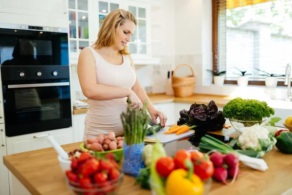 Mujer preparando comida en la isla de la cocina —  Fotos de Stock