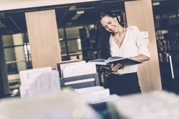 Женщина читает книги в библиотеке — стоковое фото