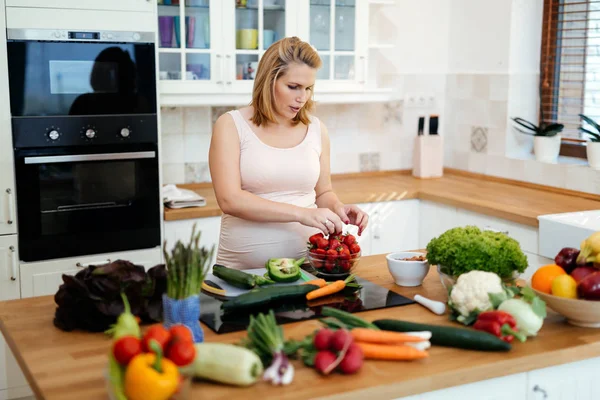 Mujer embarazada haciendo una comida en la cocina —  Fotos de Stock