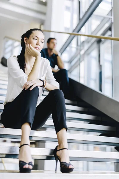Gente de negocios sentada en escaleras —  Fotos de Stock