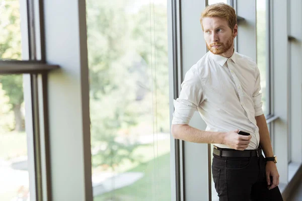 Framgångsrik affärsman står vid fönstret — Stockfoto