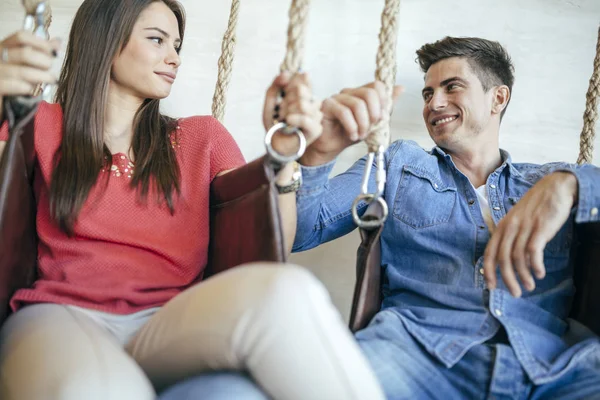 Jeune couple relaxant dans swing — Photo