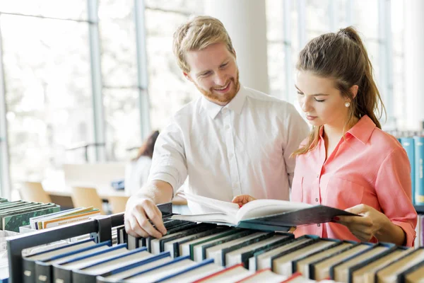 Estudiantes leyendo y estudiando en la biblioteca — Foto de Stock