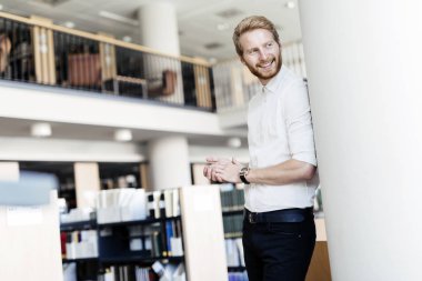 Yakışıklı öğrenci Kitaplığı'nda gülümseyen