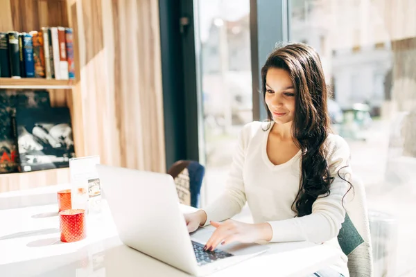 Brunette menggunakan laptop di kafe — Stok Foto