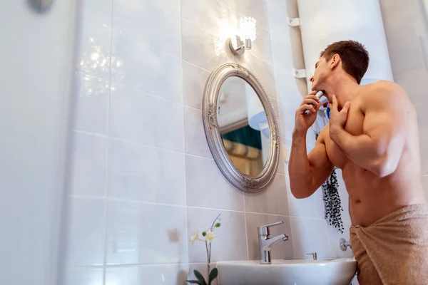 Muscular hombre afeitándose en baño — Foto de Stock