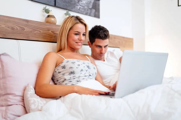 Par med laptop i sängen — Stockfoto