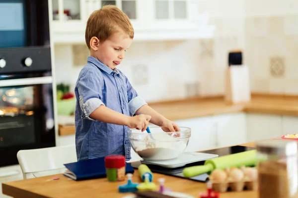 Милый ребенок учится быть шеф-поваром — стоковое фото