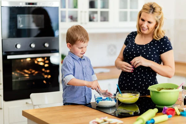 Child helping mother in kitchen