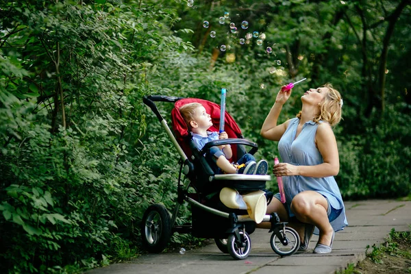 Kvinna blåser såpbubblor med barn — Stockfoto