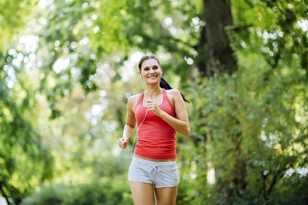 Junge schöne Athletin joggt im Park — Stockfoto