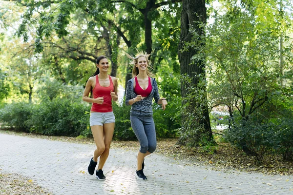 Dos mujeres jóvenes corriendo — Foto de Stock
