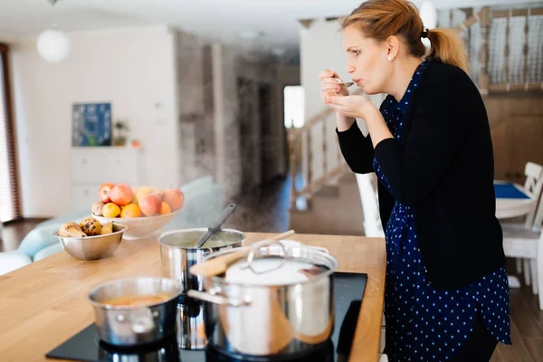 Housewife tasting food — Stock Photo, Image
