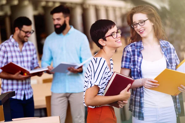 Estudiantes atractivos pasar tiempo en la biblioteca — Foto de Stock