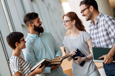 Öğrenciler üniversite kitaplığında tartışıyor