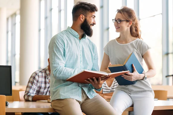 Mladá atraktivní studenti v knihovně — Stock fotografie