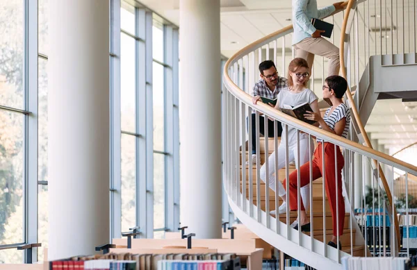 Estudiantes discutiendo en biblioteca universitaria — Foto de Stock