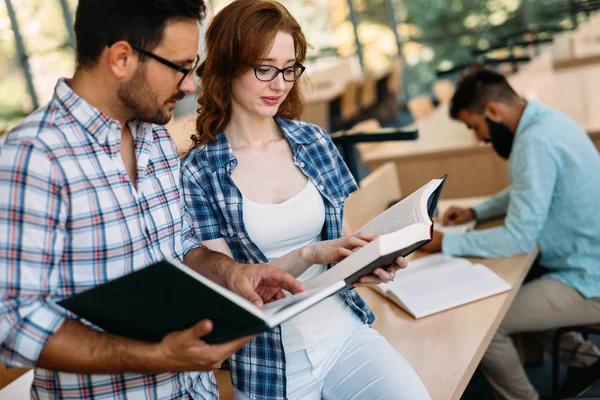 Estudantes atraentes passar tempo na biblioteca — Fotografia de Stock